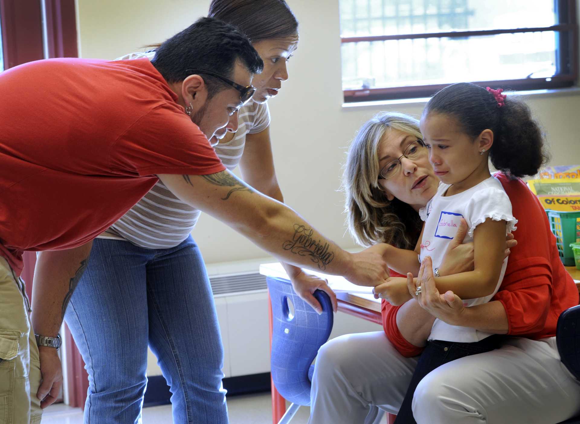 A school principal and the parents of a kindergartner, try to calm the little girl's jitters on the first day of school. 