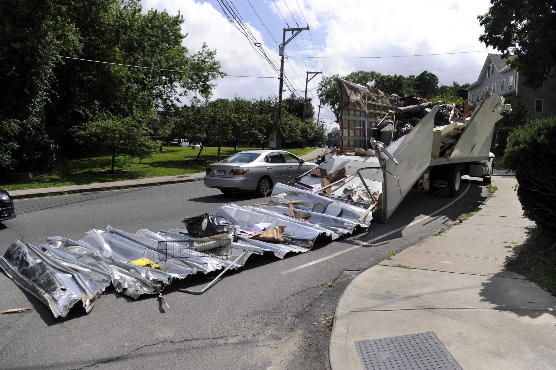 A moving truck too tall to make it under a city bridge had its top completely severed. 